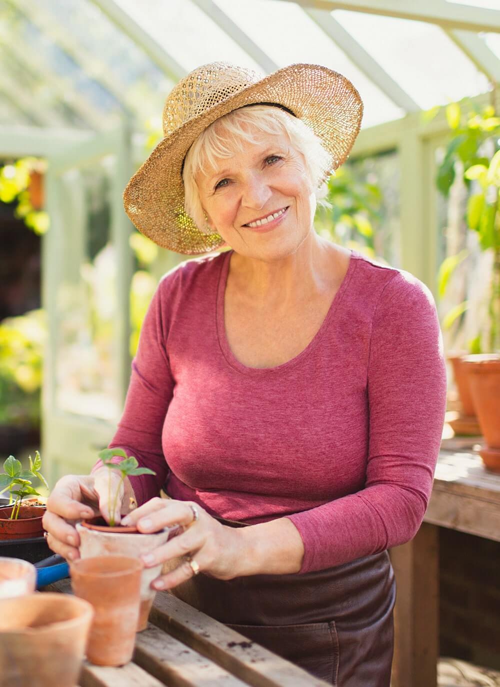 womandecisionmaker Smiling senior woman potting a plant